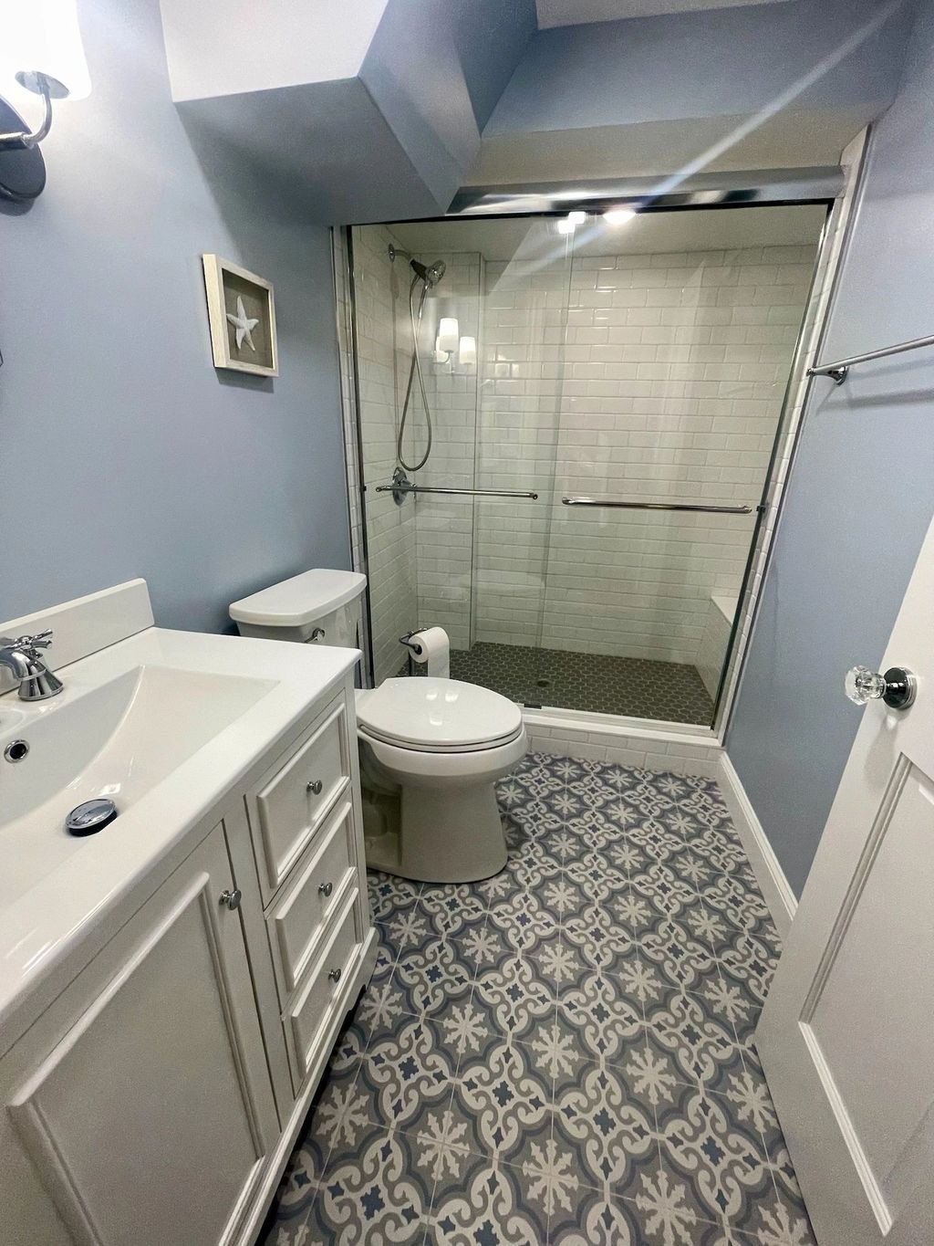 Bathroom with walk-in shower and patterned tile floor